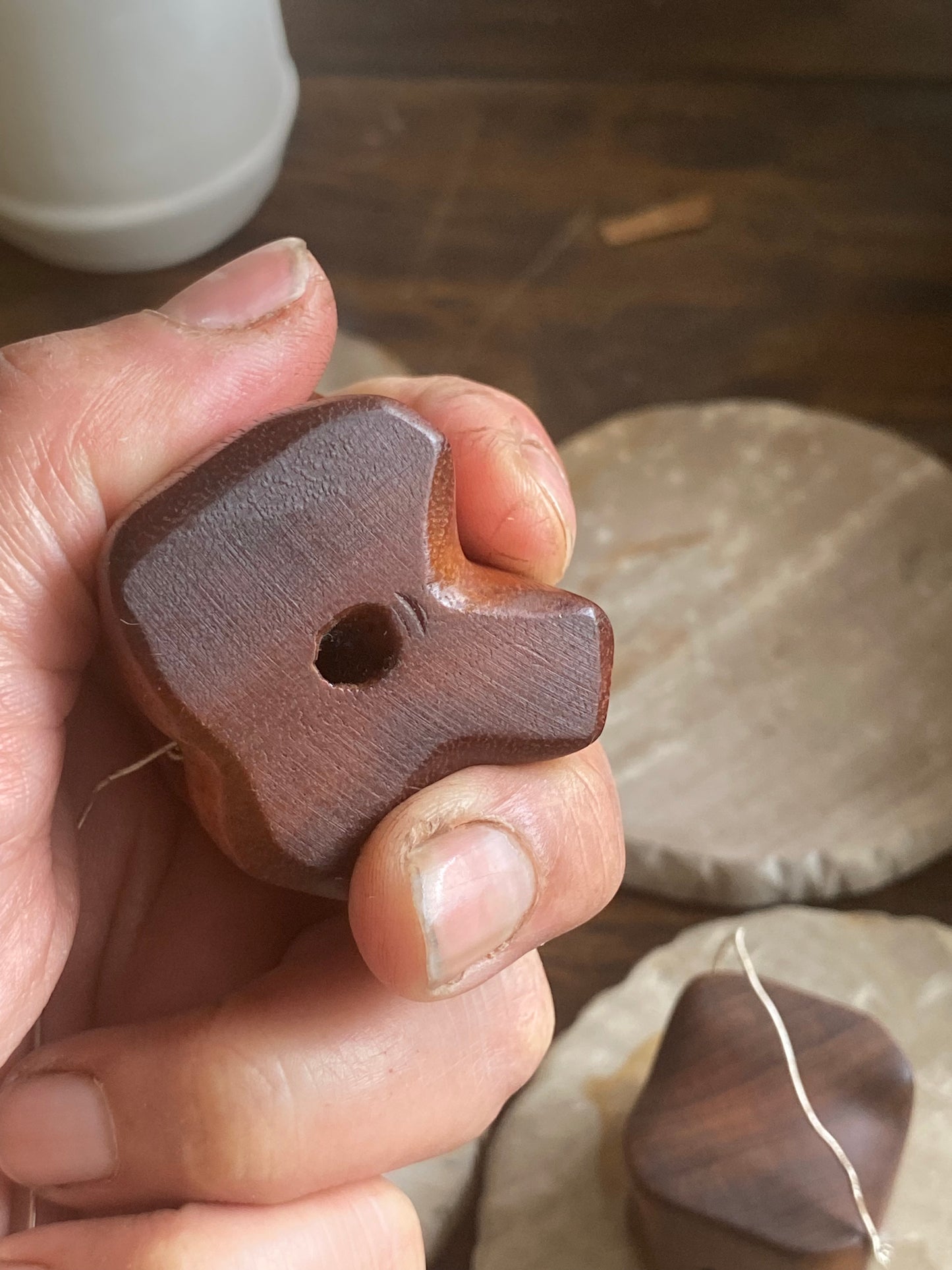 typical fingers with healed scars holding clay cutter showcasing fit around fingers